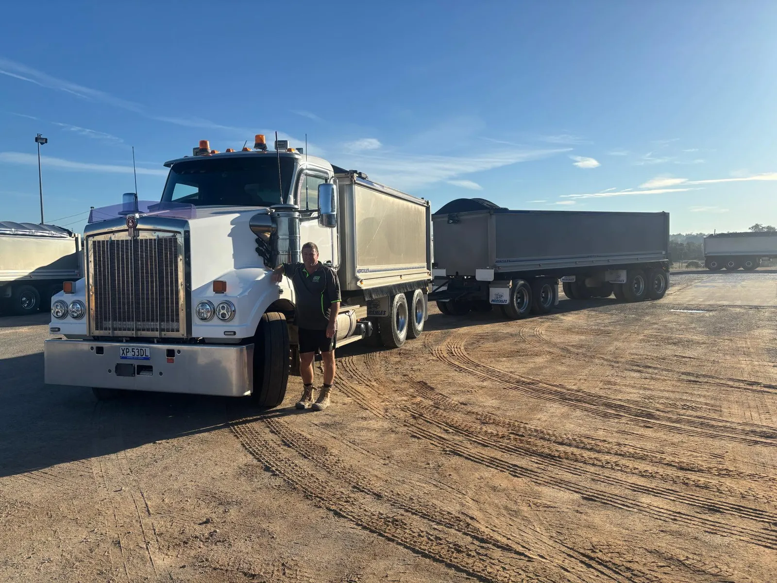 Greg Bell standing beside the GB Civil Kenworth tipper and dog trailer