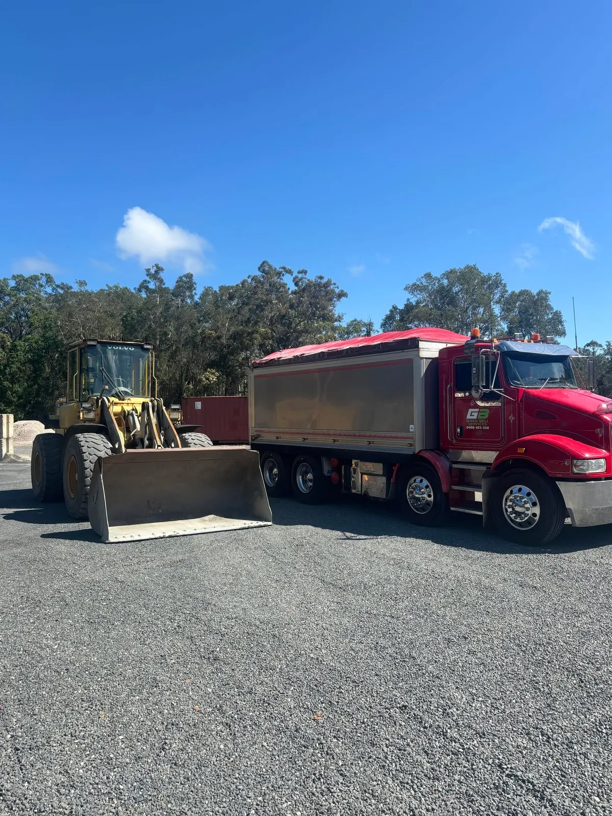 Wheel loader and tipper truck loading roadbase at the yard