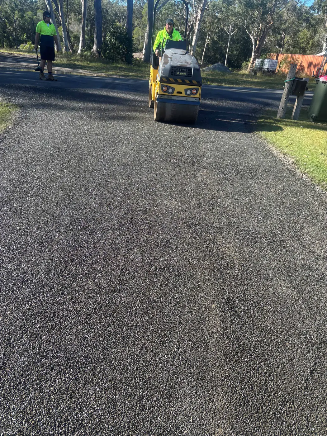 Roller compacting fresh asphalt on a rural road resurfacing job