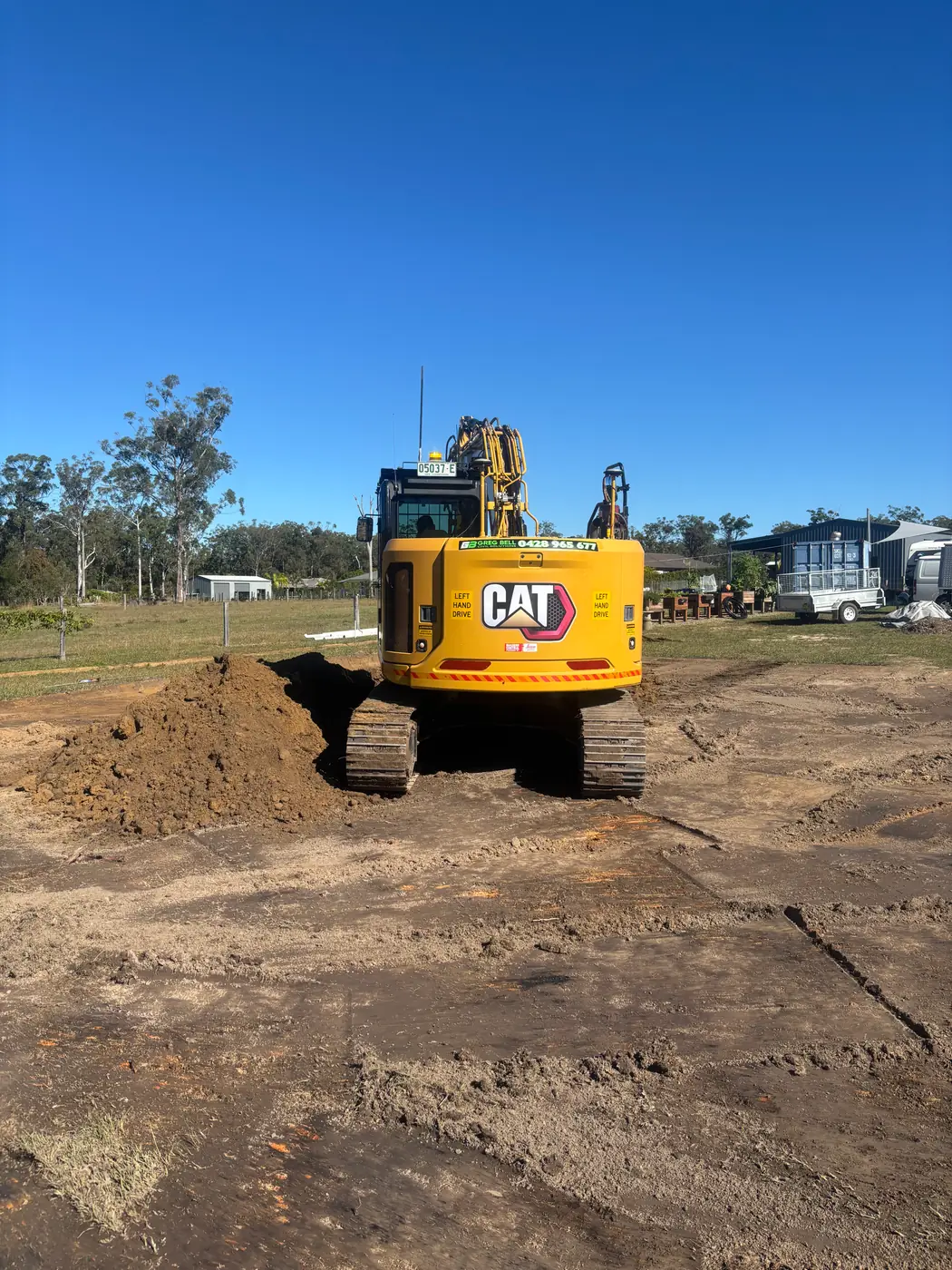 CAT excavator trimming the pad to level