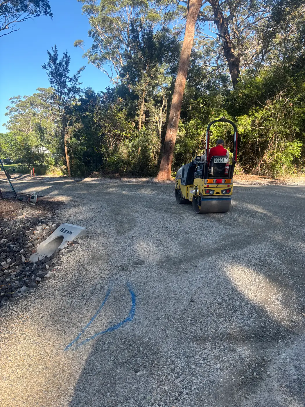 Roller compacting a new gravel driveway