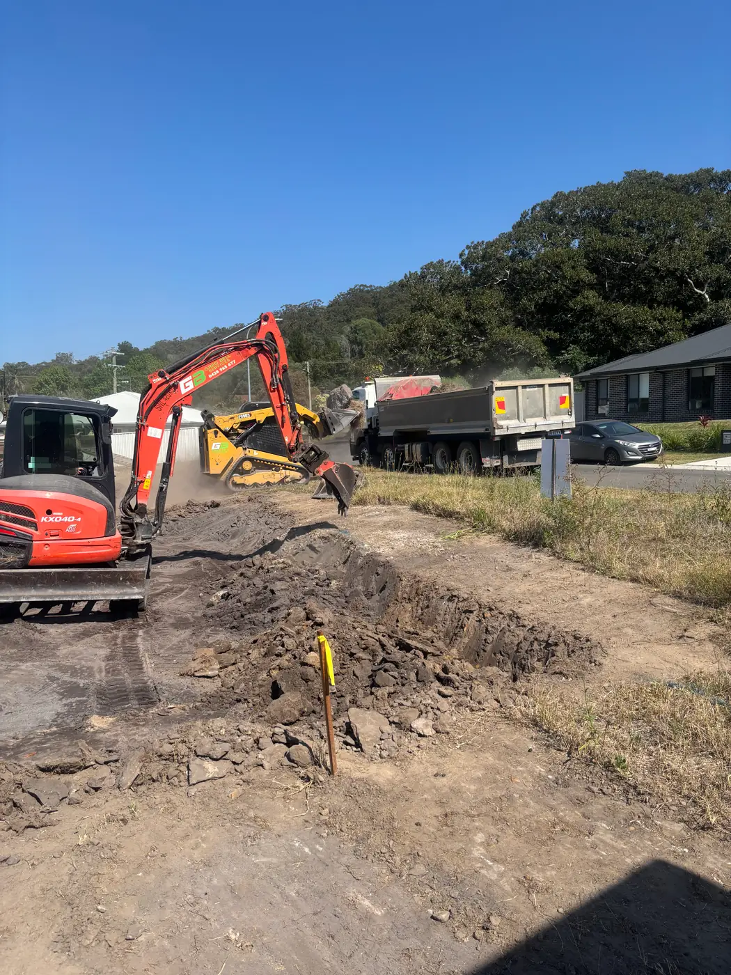 Mini excavator working beside a rural road